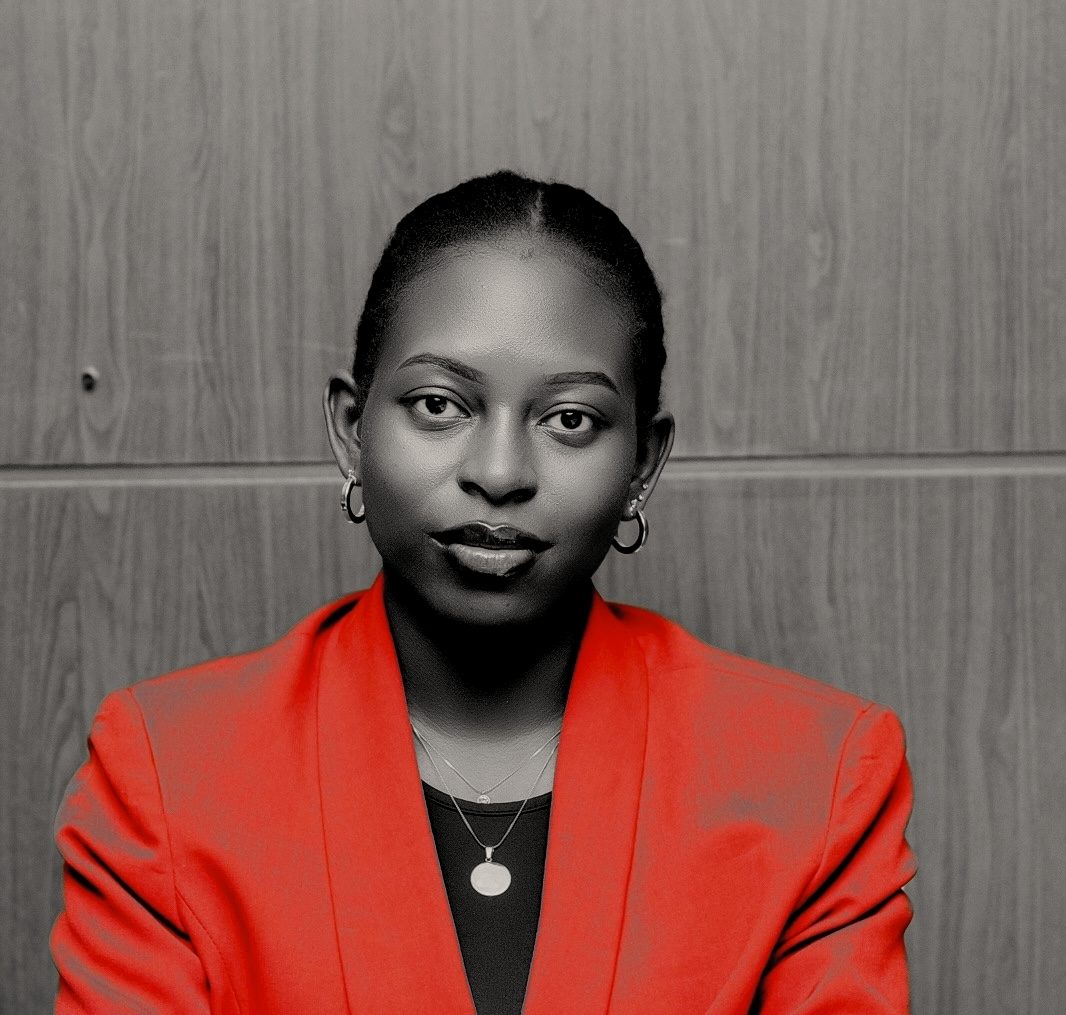 Doria Igiraneza in a red blazer, looking straight at the camera